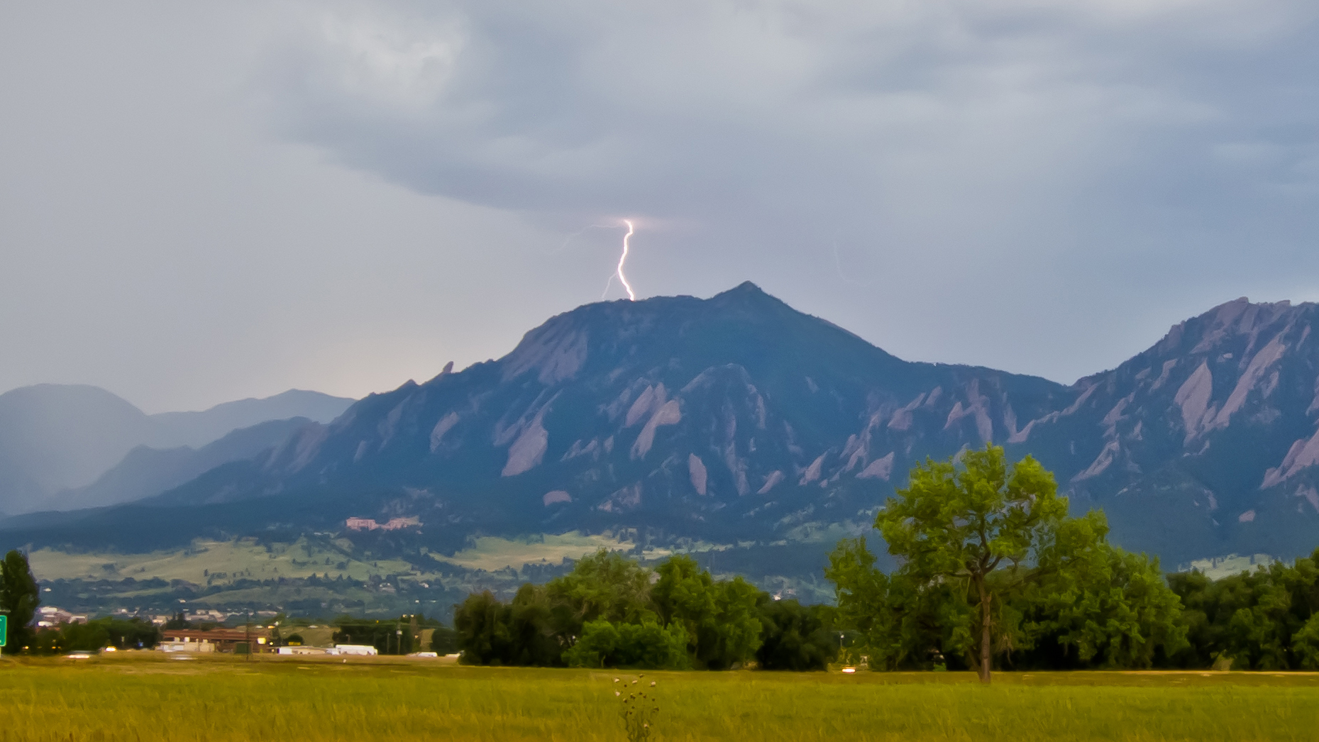 Lightning strikes the top of the Boulder mountain backdrop.