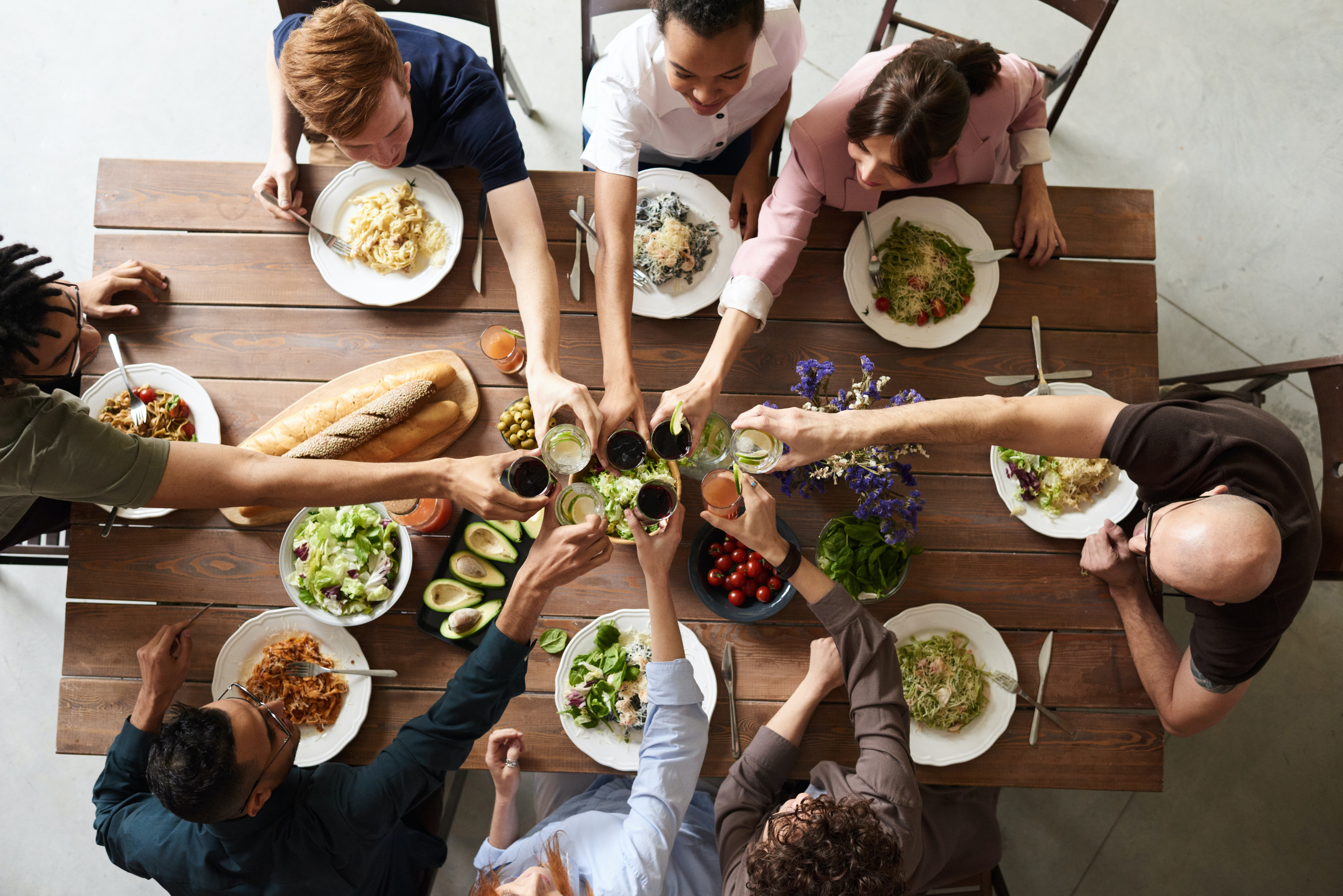 People clinking glasses before having dinner