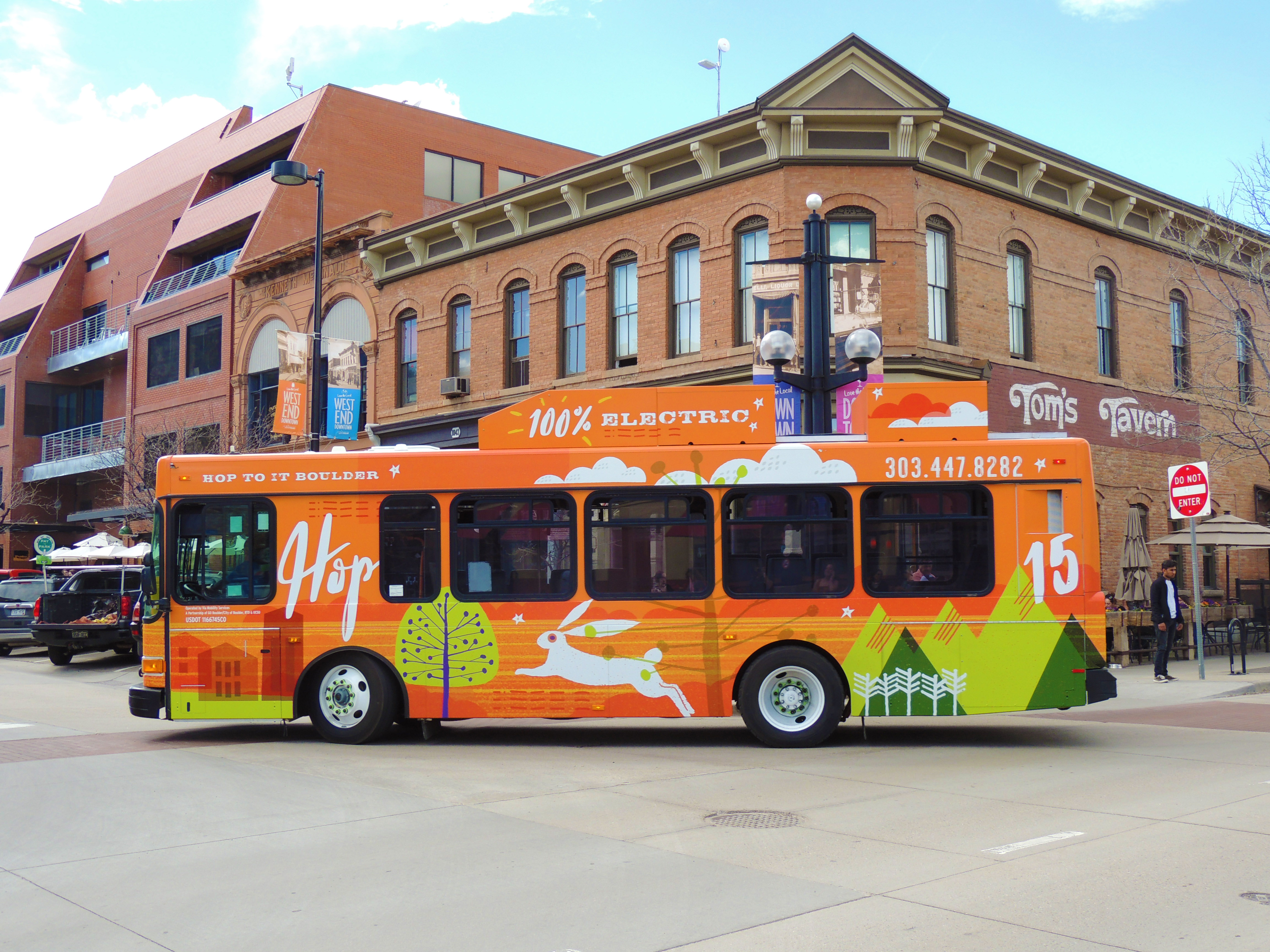 A bright orange bus turning right