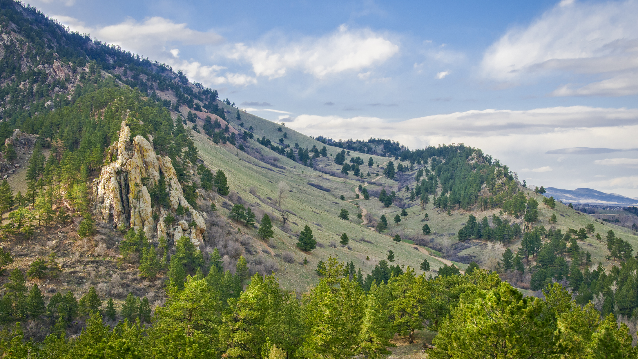 Clouds pass over Mount Sanitas and the Sanitas Valley Trail