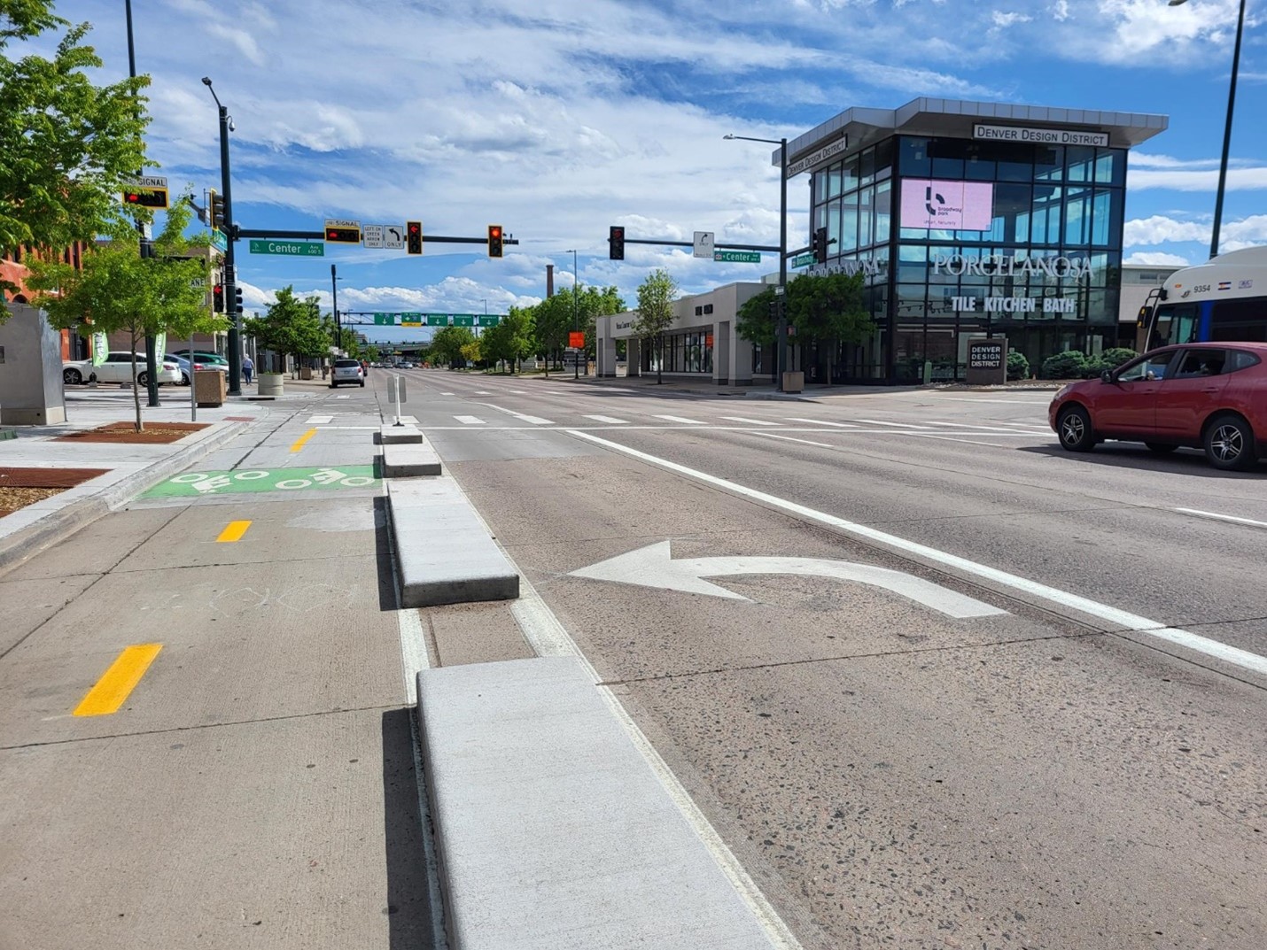 Two-way bike lane example in Denver. Low raised concrete separates the bike lane from the driving lane.