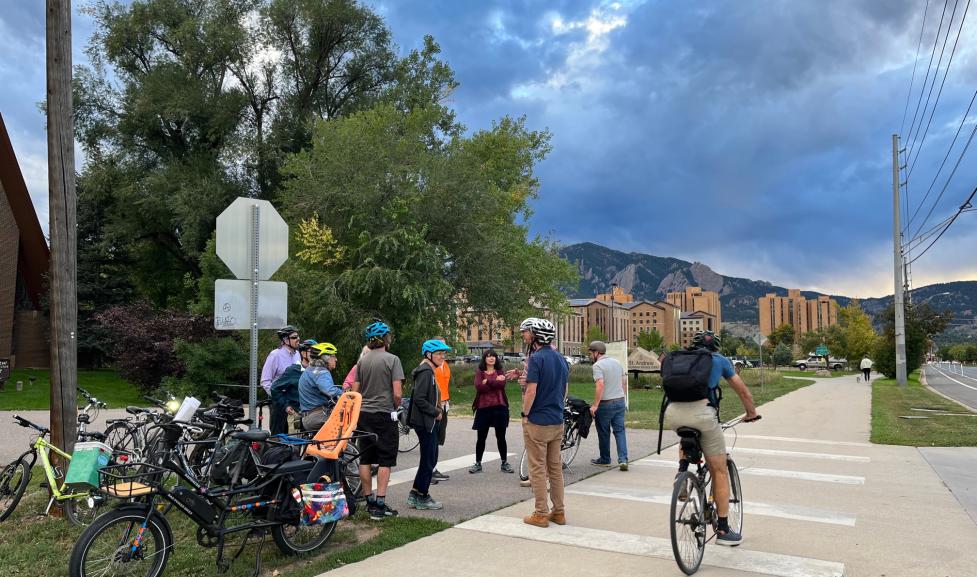 People talking, gathered next to bikes on Baseline Road