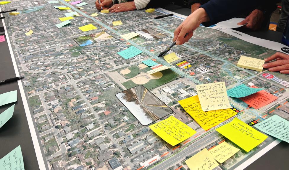 People writing down feedback and pointing to a map of Iris Avenue.