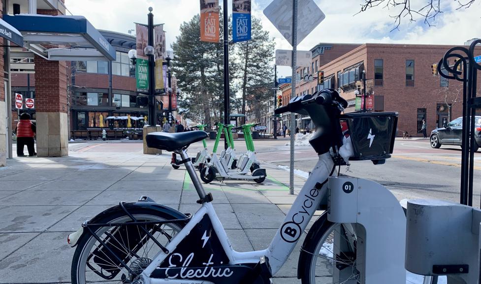 E-bicycle and Lime scooters parked downtown.