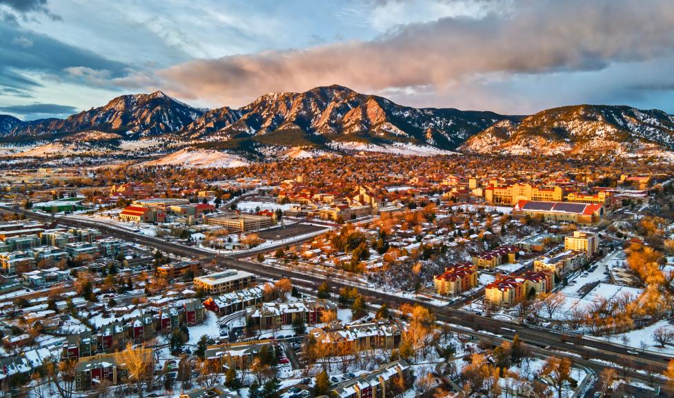 Drone view of University of Colorado, Boulder and the Flatirons at sunrise in the winter snow.