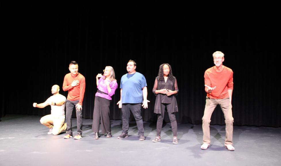 Six diverse people acting on a stage, each showing a different emotion.