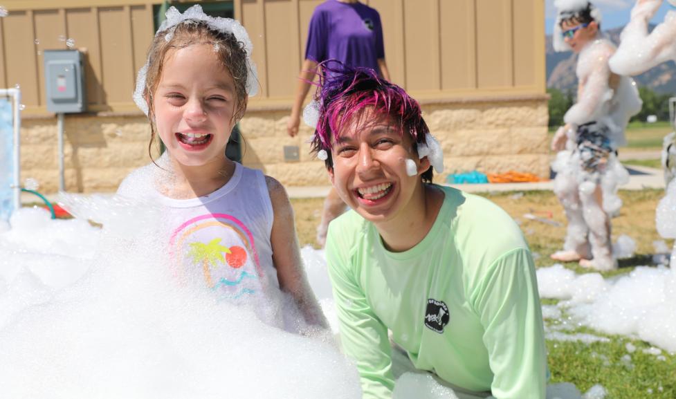 Camper and camp counselor enjoying the bubble party at Kidz Kamp.