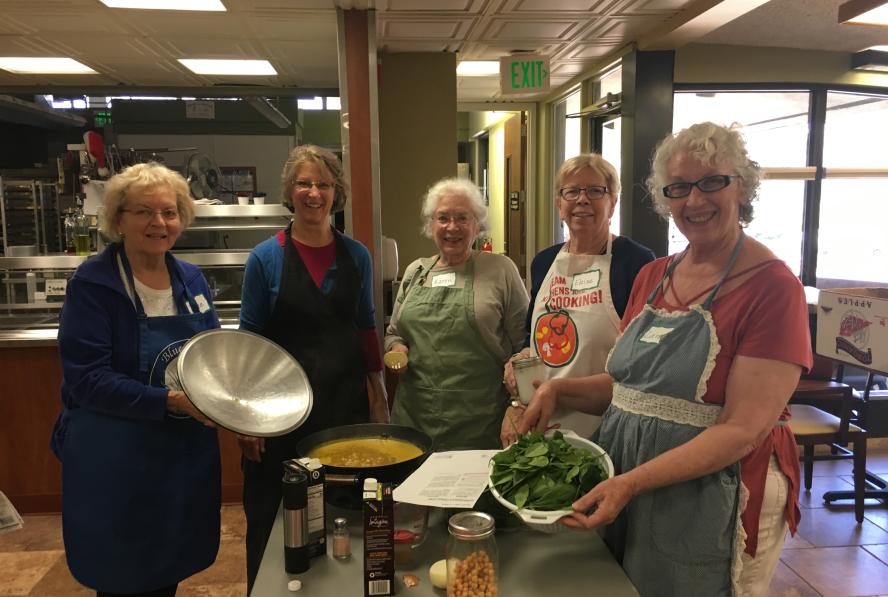 Group of five people smiling for the camera during a cooking class at the age well center.