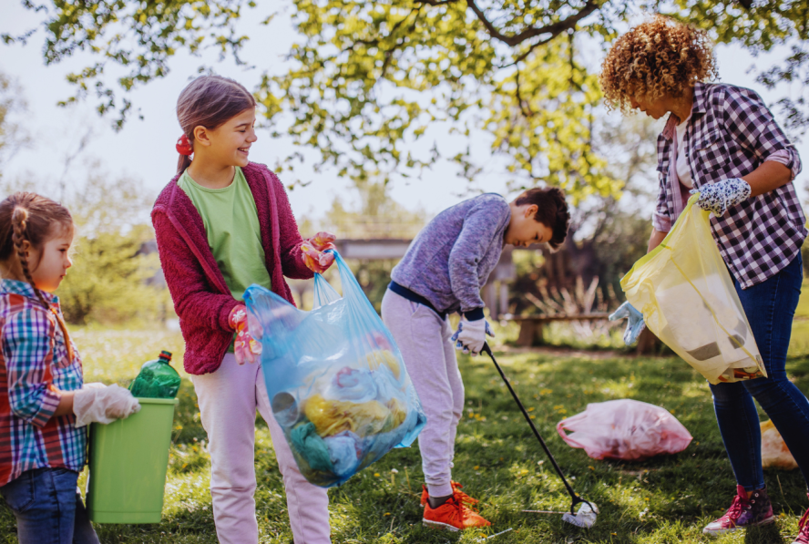 Kids and an adult picking up trash at a local park