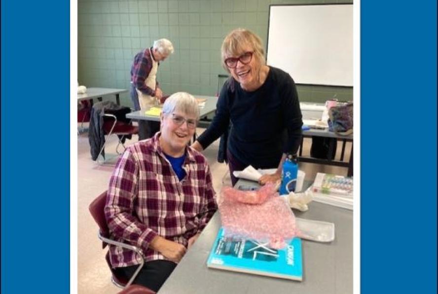 January program guide cover image: Watercolor instructor Sally Elliot, smiles alongside a class participant.