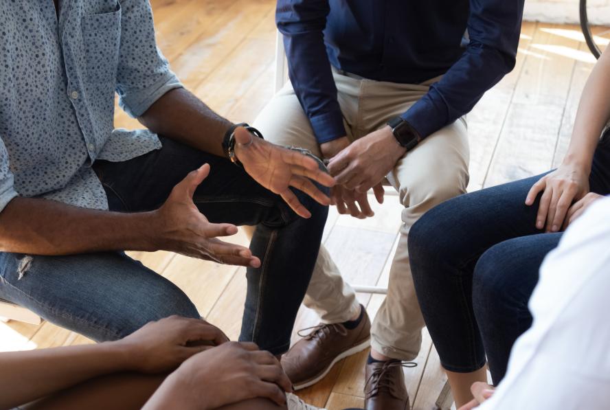 Group of racial diverse people sitting in a circle having a discussion.