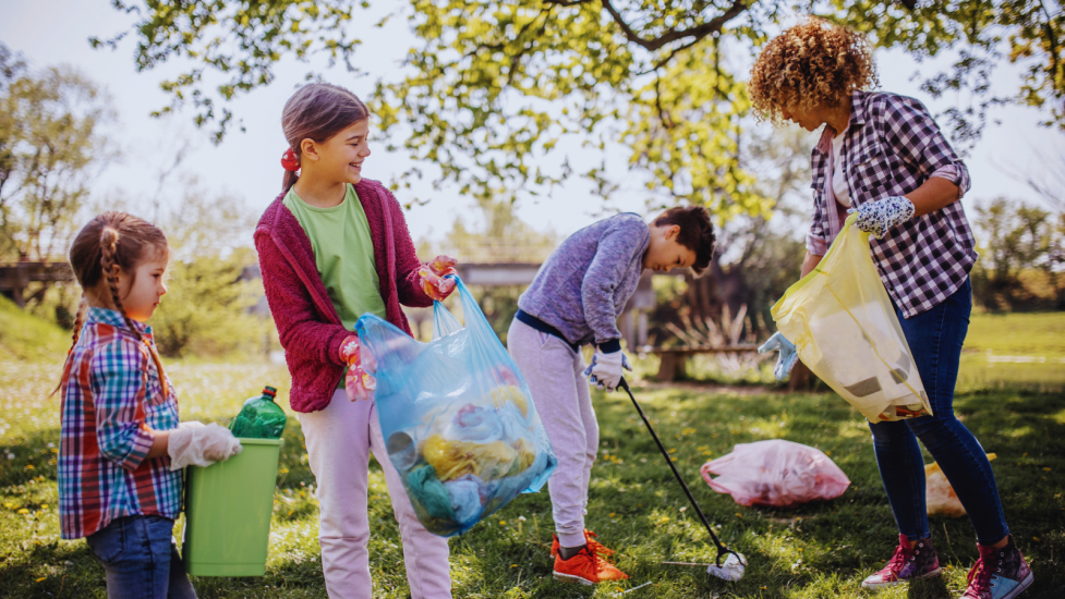 Kids and an adult picking up trash at a local park