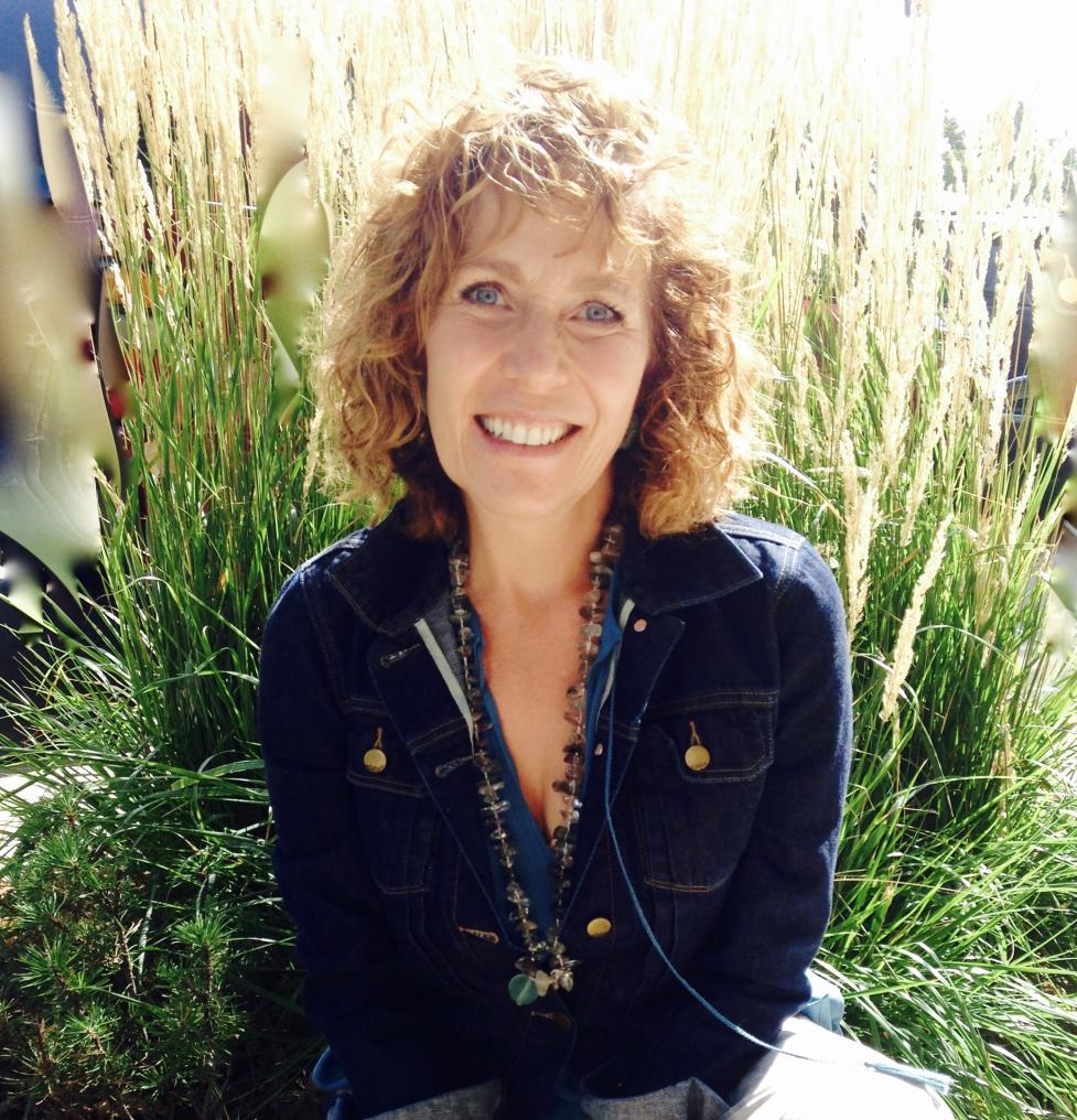 Andrea Montoya smiling at the camera in a dark blue jacket. 