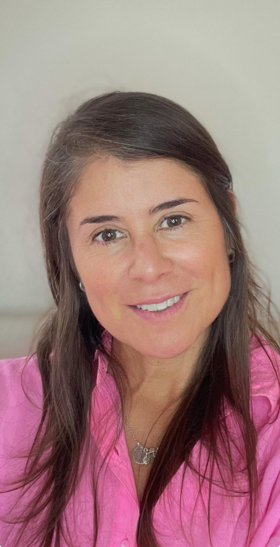 Selfie of Sandra Salazar smiling and wearing a pink shirt.