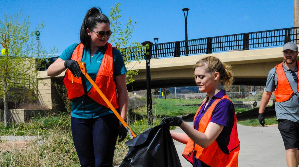 Two people picking up trash