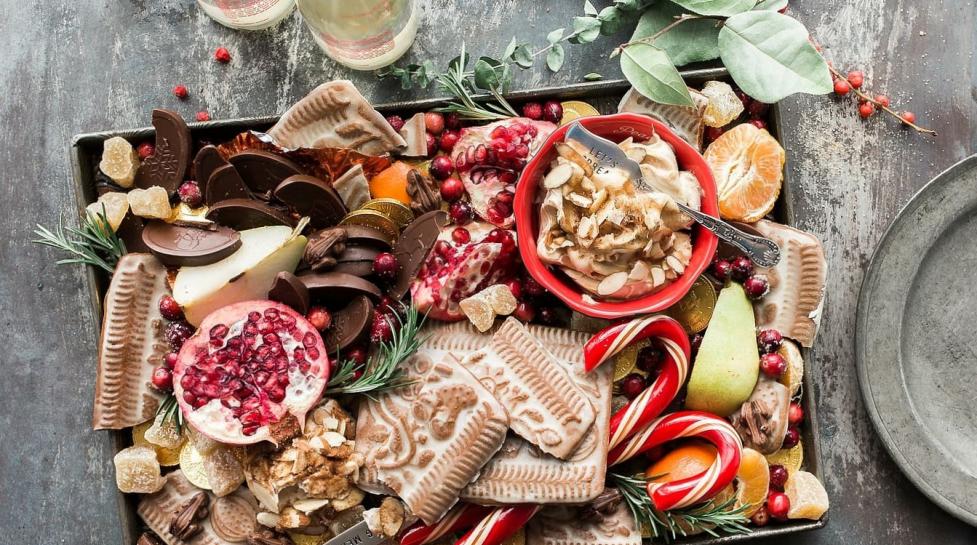 Fruit, cheese chocolate and holiday flowers on a serving platter