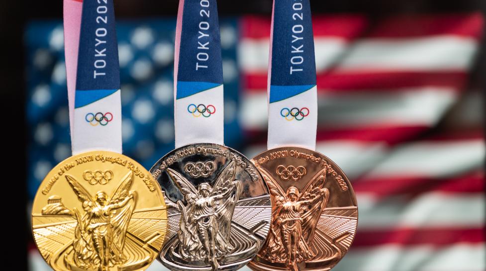 Gold, silver and bronze Tokyo Olympics Medals hang in front of the US flag