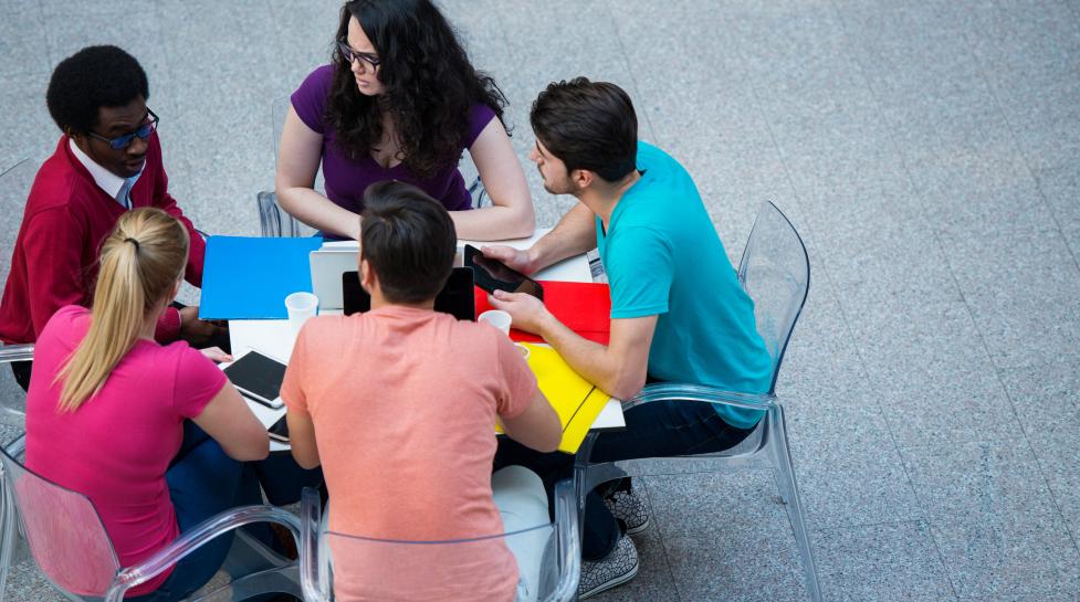 Group of five individuals collaborating around a table