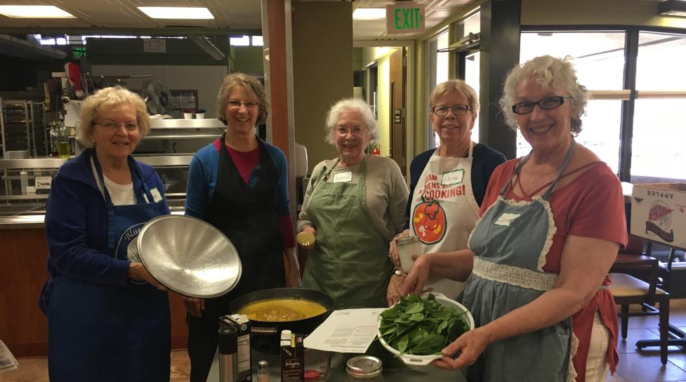 Group of five people smiling for the camera during a cooking class at the age well center.