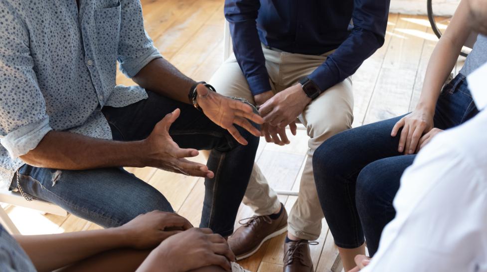 Black man counselor speaks at group counseling therapy session