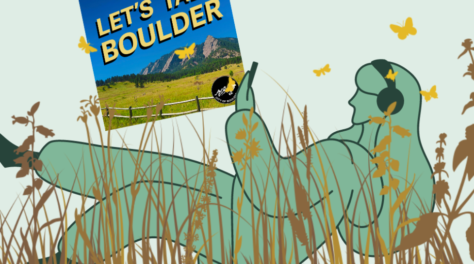 Person lying in the grass listening to Let's Talk Boulder podcast