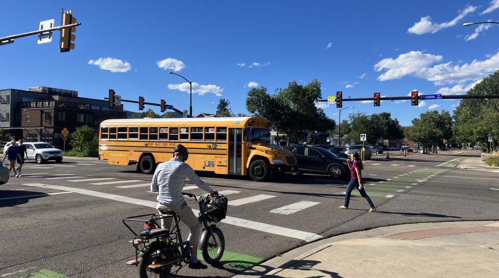 Pedestrians, a bicycle, a bus and other vehicles converge at the Folsom Street intersection.