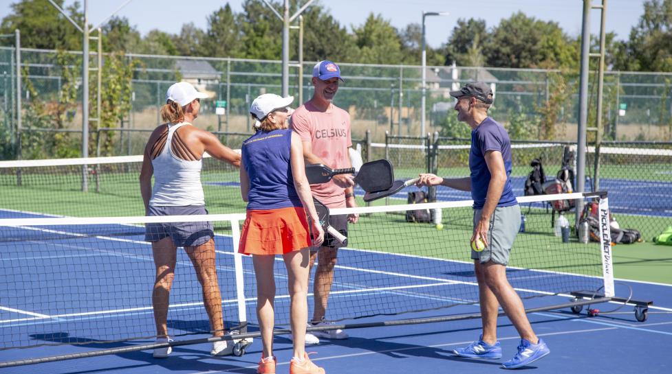 Community members playing on a racket sport court