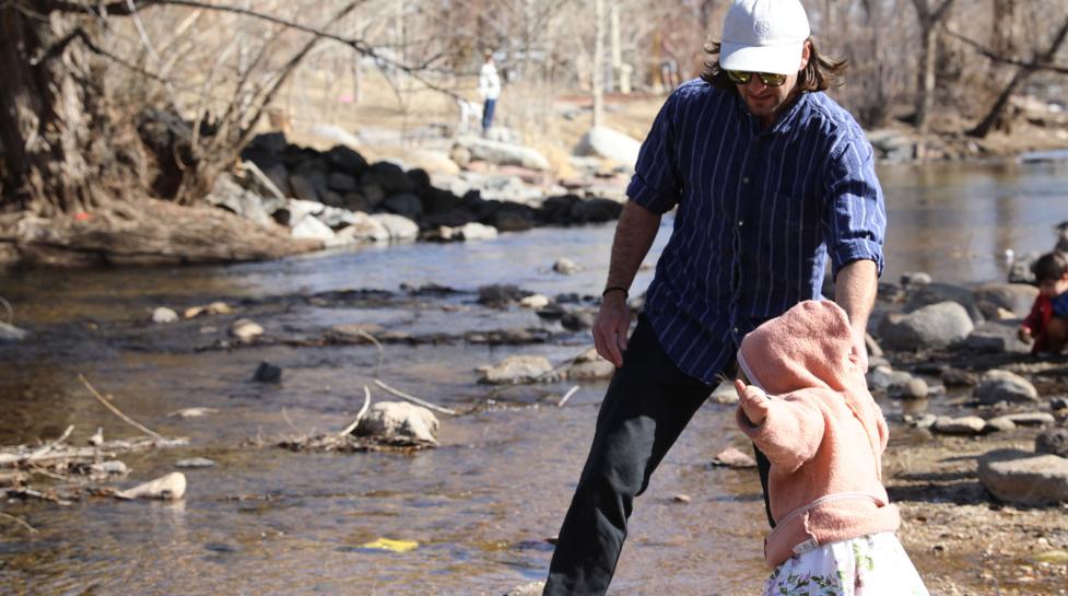 A father and his daughter play in Boulder Creek in the Civic Area park