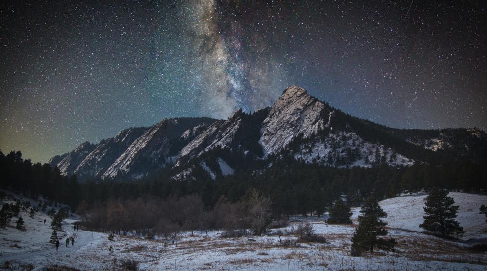 A starry night winter scene above the Flatirons in Boulder