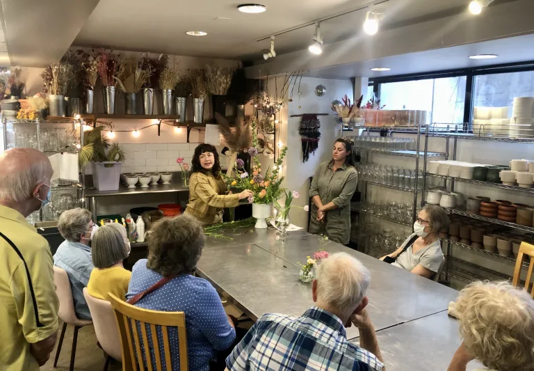 Older adults taking a flower arranging class. 