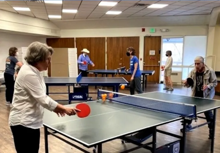 Older adults playing table tennis. 