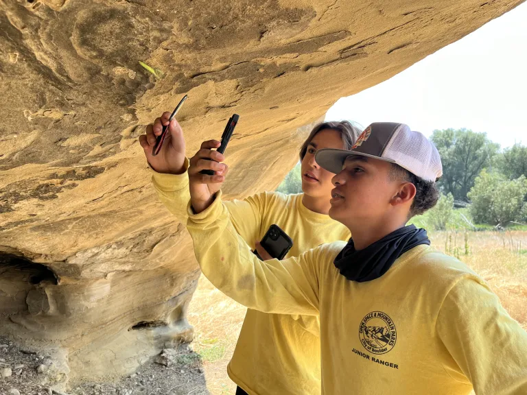 Junior Rangers use hand lenses to observe a rock formation