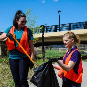 Two people picking up trash