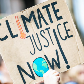 A protest sign with the message: Climate justice NOW!