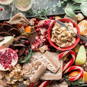 Fruit, cheese chocolate and holiday flowers on a serving platter