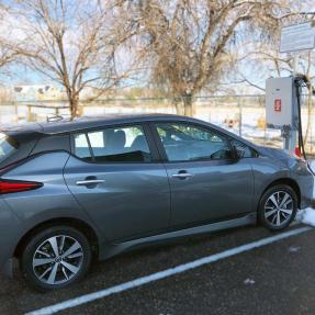 A grey Nissan Leaf is plugged into a bi-directional charger at the North Boulder Recreation Center