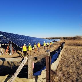 A team of BHP residents in yellow safety vests install a solar garden north of Boulder