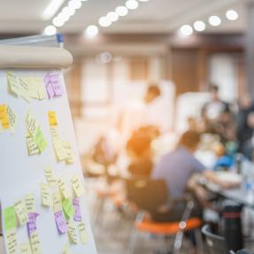 Sticky notes on board with meeting in background