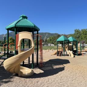 Existing playground structures with slides at North Boulder Park. Mountains in the background