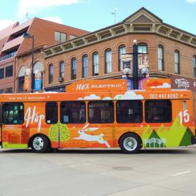 A bright orange bus turning right