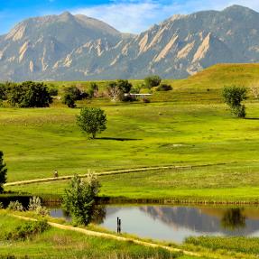 Distant view of the Flatirons and bikers on Open Space