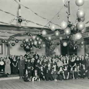 A scene with balloons and a group celebration from the 1920s.