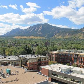 Photo of city buildings with Boulder's mountains behind them.