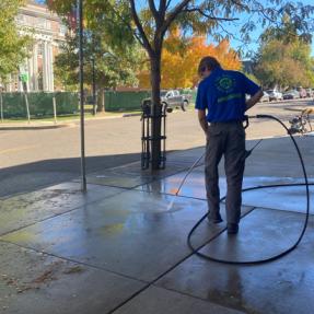 University Hill Ambassador cleaning up the sidewalk.