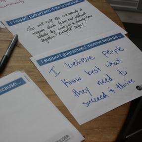Paper with the prompt 'I support guaranteed income because...' that reads 'I believe people know best what they need to succeed & thrive'