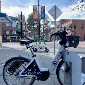 E-bicycle and Lime scooters parked downtown.