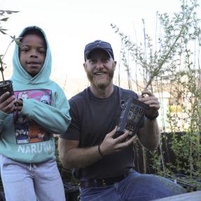 City Forestry staff and community member hand out tree seedlings