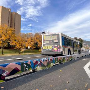 Bus along Baseline Road in the fall next to a concrete-tall-curb protected bike lane