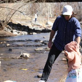 A father and his daughter play in Boulder Creek in the Civic Area park