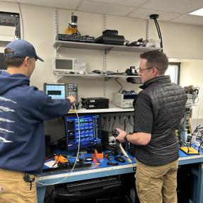 Two city staff members working on a piece of radio equipment to support communications across first responders in Boulder.